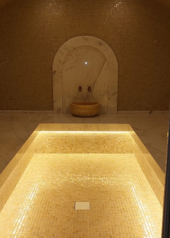 Турецкая баня в отделке из мозайки нежного бежевого цвета.